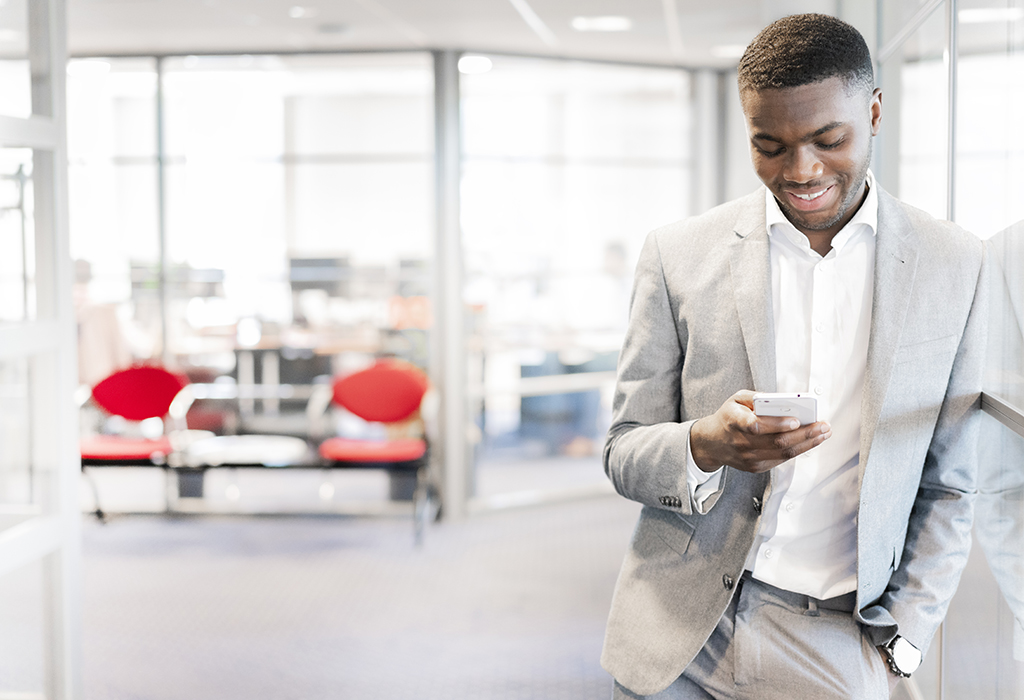 Man managing tank container services online on his mobile phone 