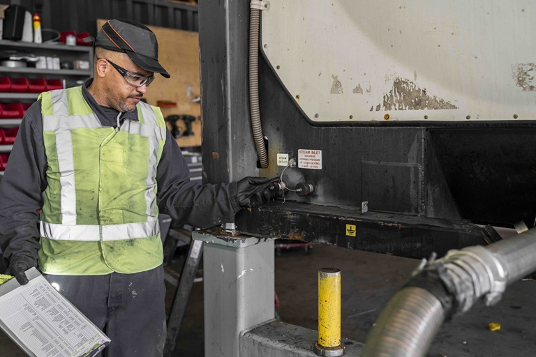 Depot technical worker inspecting a tank container